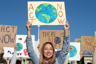 Climate rally with girl smiling holding sign