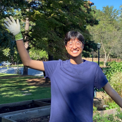 Tytus standing outside waving and smiling