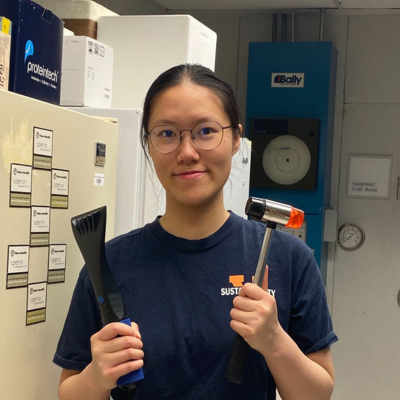 Yushun standing smiling with tools