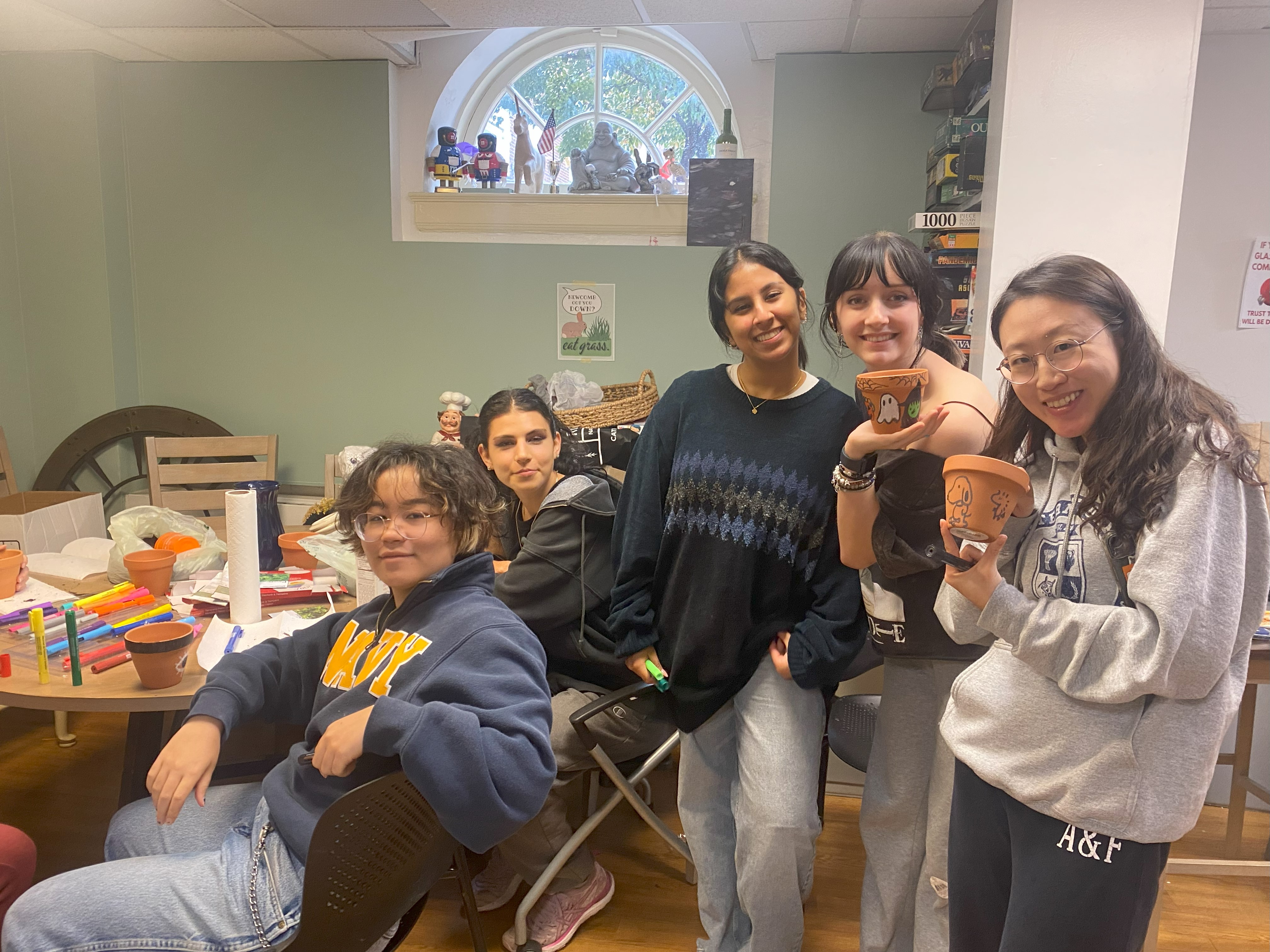 Five students participating in a pot decorating activity.