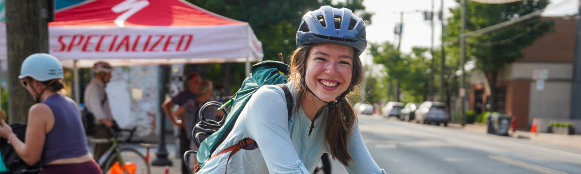 Bike commuter with helmet on smiling outside