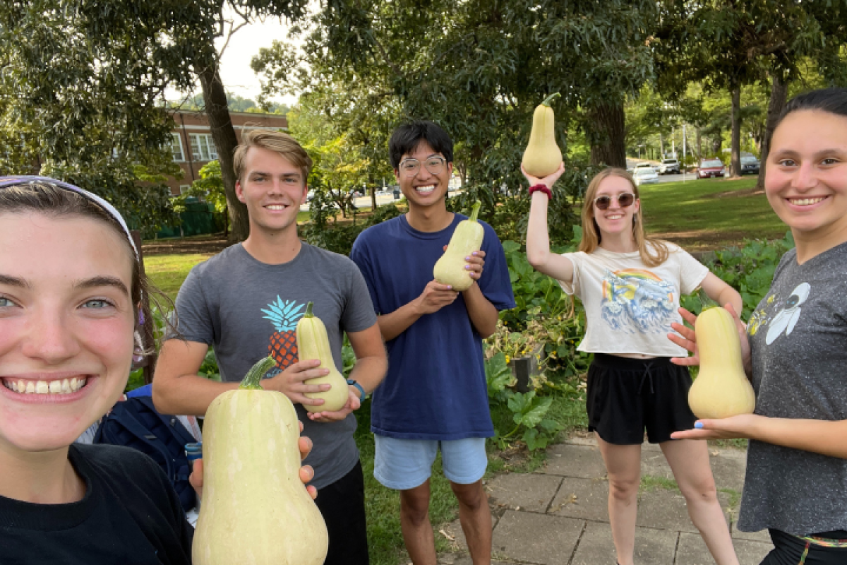 Five students holding up their home-grown squash from student garden