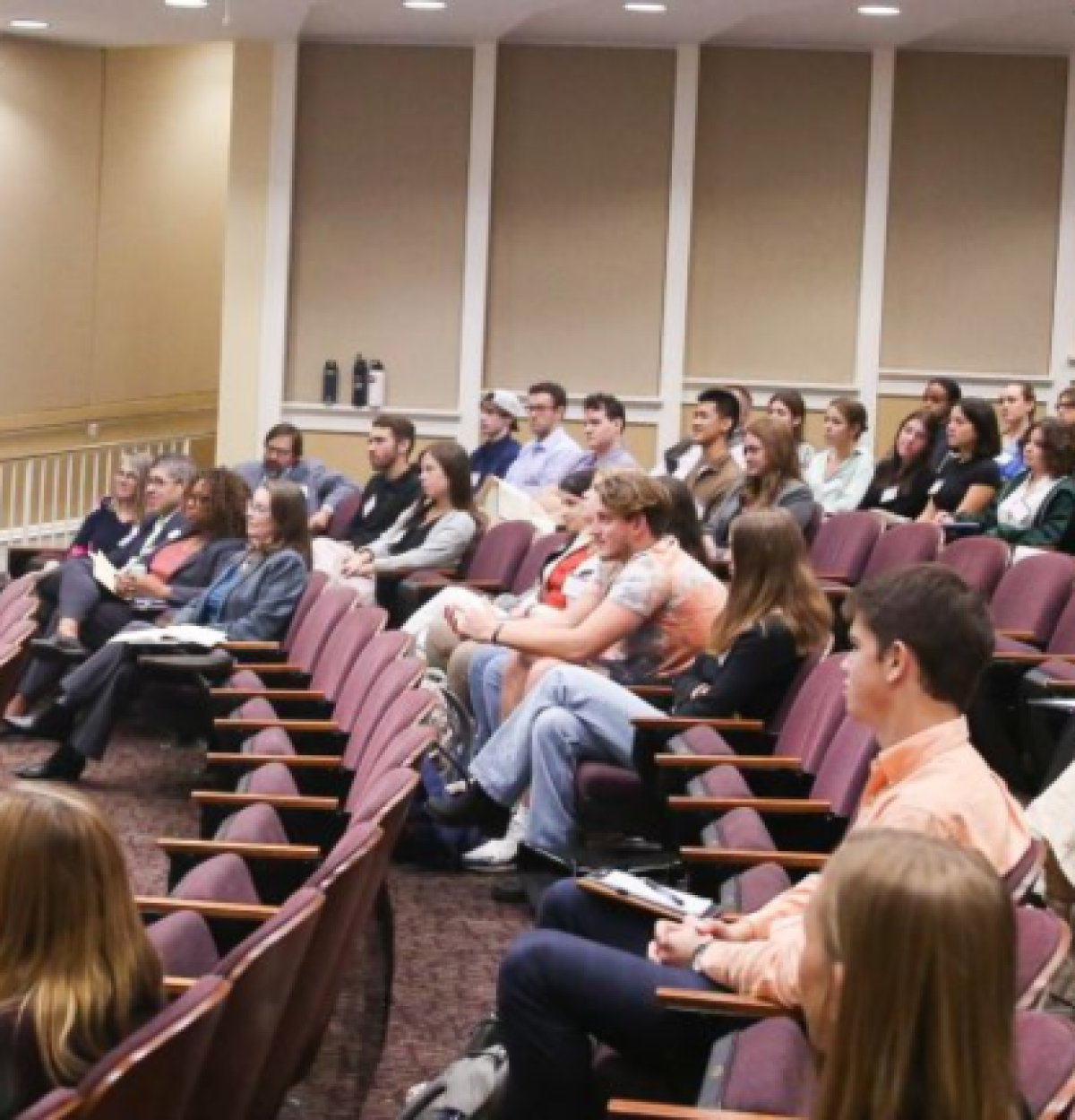 People sitting in a lecture hall listening to speaker