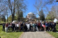Students pose with trash pickers and bags in front of the Rotunda