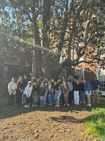 A group of UVA students standing under a large tree.
